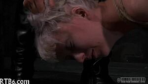 in the dungeon, a dominant woman controls her submissive partner with whips and chains