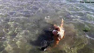 Milf plays with her big tits and ass on public beach