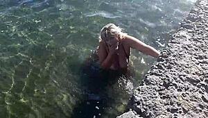 Milf plays with her big tits and ass on public beach