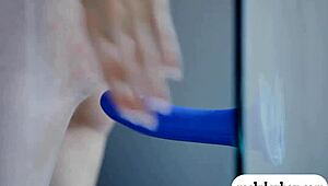 two attractive babes fucking a blue dildo while licking each other passionately