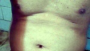 Old Indian gay bottom enjoys his own golden shower casually. He bends over for the flow.