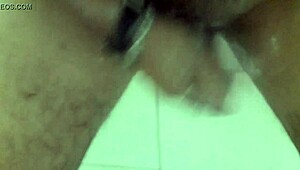 In the shower, he pleasures himself with a dildo