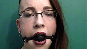 dark lipstick BALLGAG DROOLING with intense eye contact in close-up.