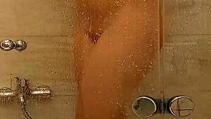 She caresses herself in the bath with big tits and ass