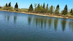 in a quiet forest after school a young angler girl sets up her fishing gear by the water enjoying the peaceful nature around her