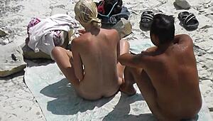 Voyeur catches slim blonde jerking with her boyfriend at the beach
